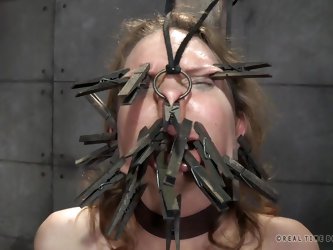 The mean master and dominatrix are placing clothespins on the slut slave's face. They want to see how many they can fit on there. She is bound an